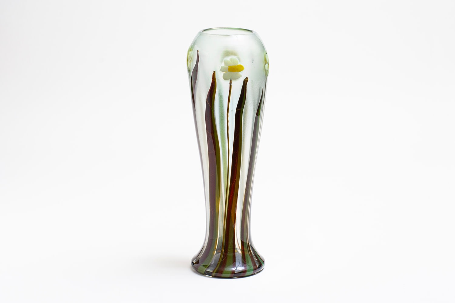 a tall and thin tiffany glass vase depicting white and yellow narcissus or nasturtium blossoms on tall thin stems with spiky green/brown leaves