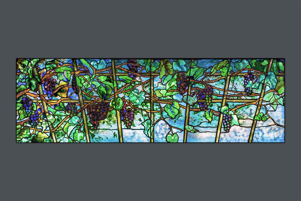 A spectacular antique original Tiffany Window depicting a Grape Arbor with grapes formed by rounded pressed pieces of glass in shades of purple and blue, with exceptional custom Tiffany Glass known as &quot;foliage&quot; glass - in mottled blue with pieces of green glass &quot;confetti&quot; to represent leaves against a sky.