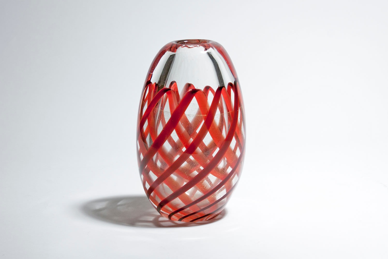 a midcentury italian glass vase, a thick layer of clear glass encasing a motif in in the lower ⅔ of thick red bands of glass overlapping in a &quot;lattice&quot; style pattern, with a thin layer of gold sparkle in between the layers of red.