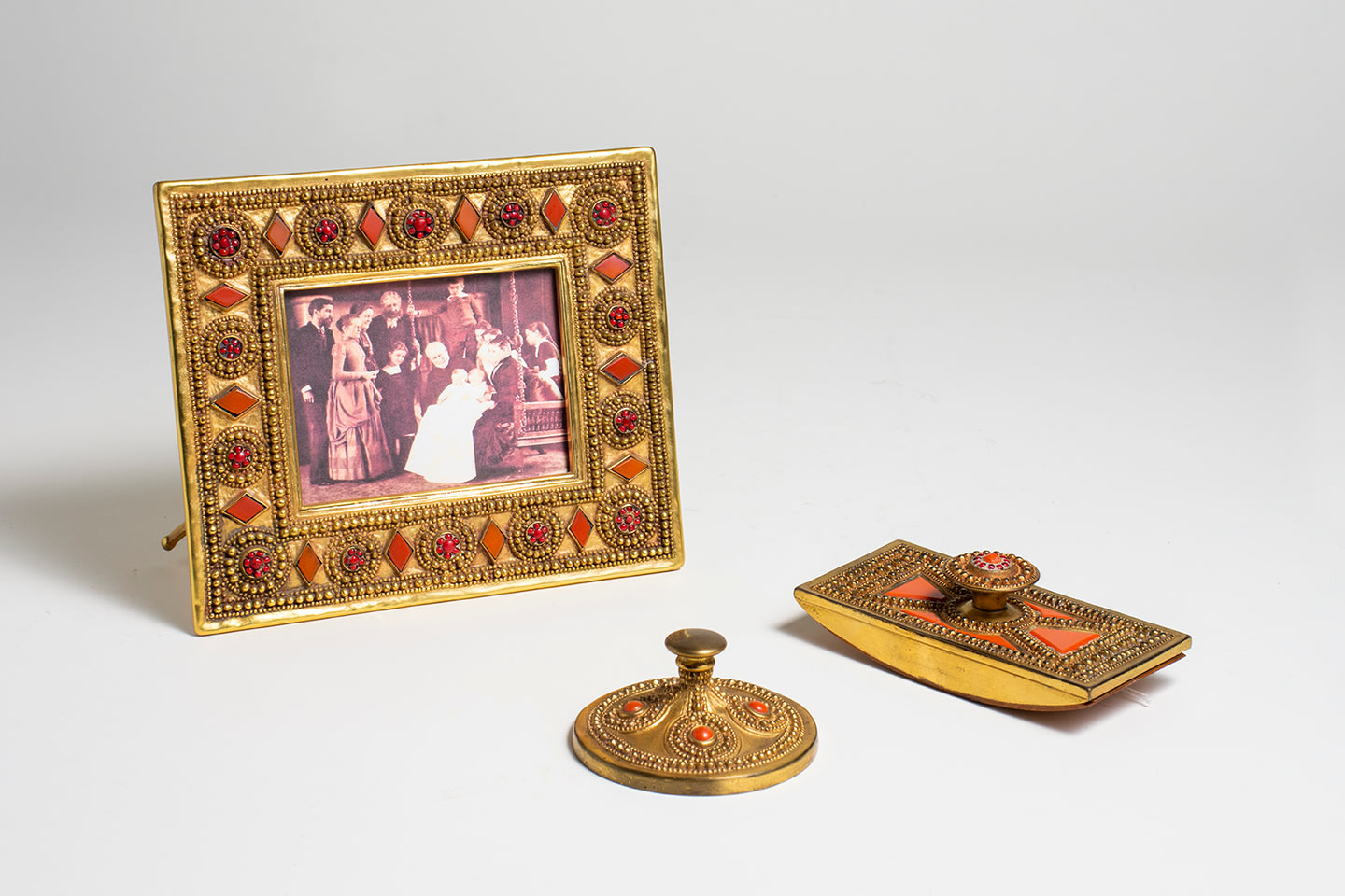 a gilt bronze desk set by tiffany studios in the BYZANTINE pattern, with inset red pieces of glass mimicking enamel and stone work with elaborate raised metalwork details