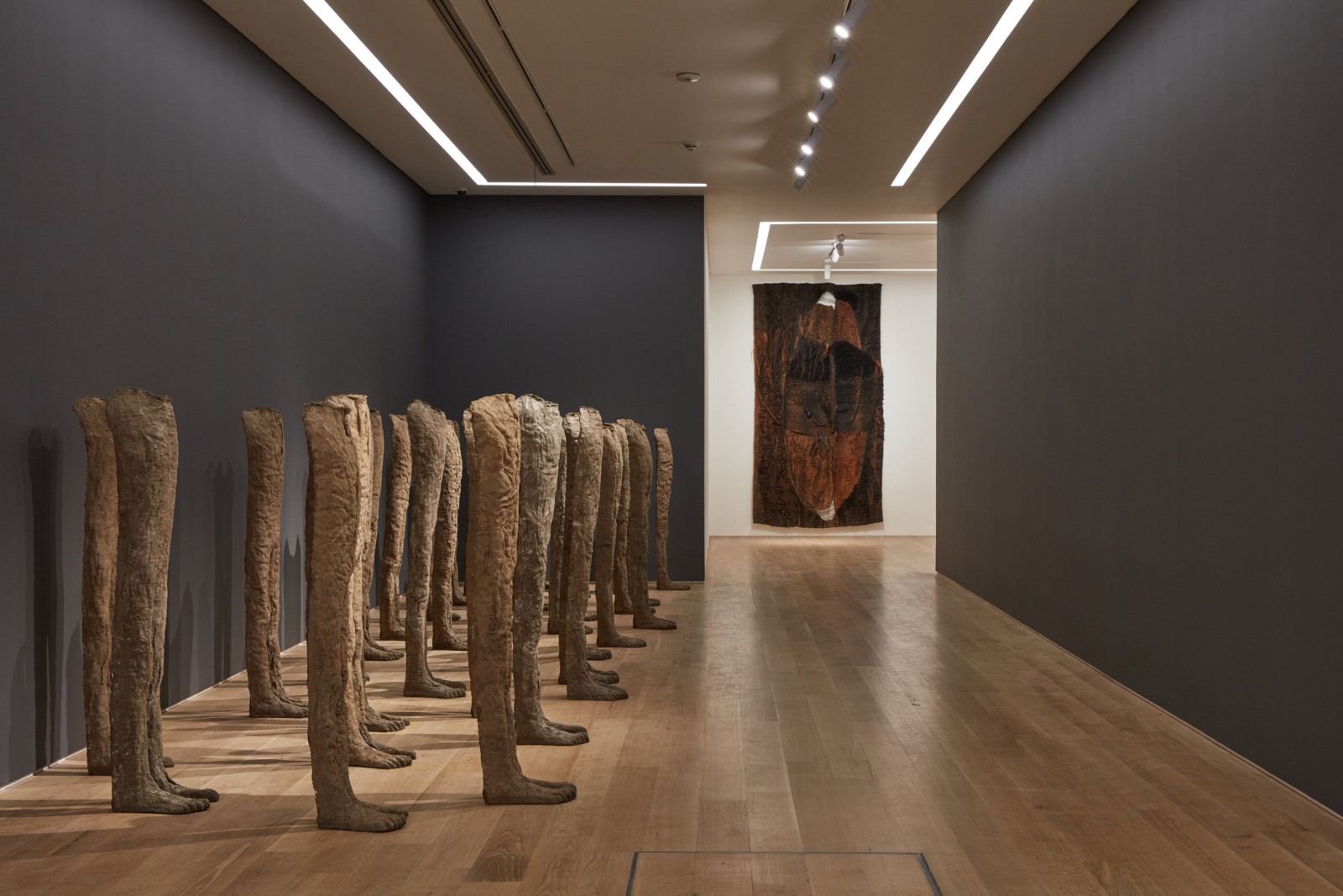 Installation view of burlap and resin sculptures and a textile work by Magdalena Abakanowicz