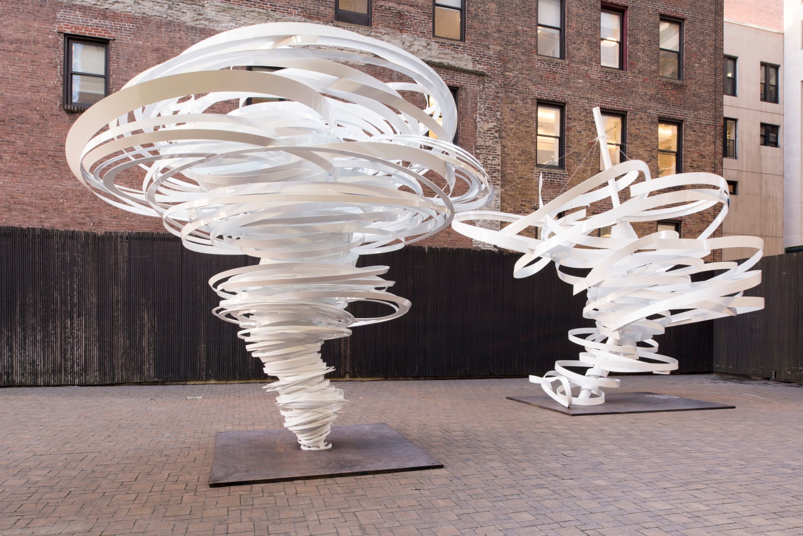 Outdoor installation view of white aluminum twisted sculptures by Alice Aycock