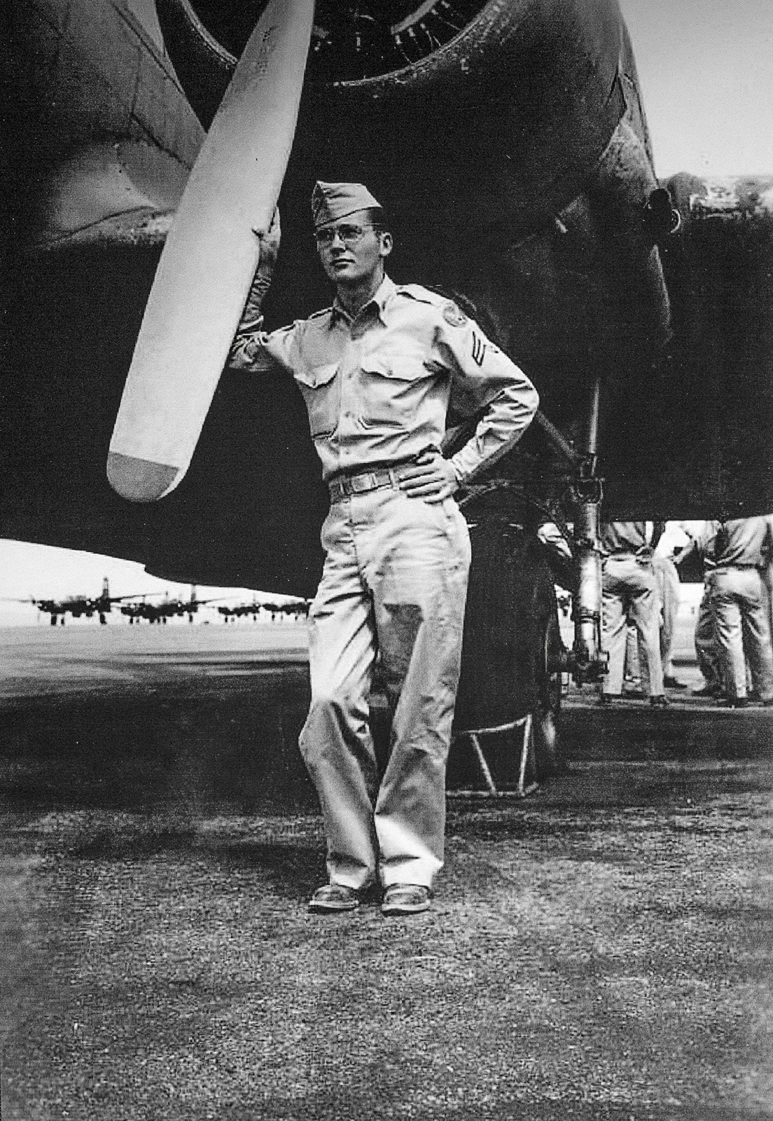 A black and white photograph of Robert Clark, in uniform, standing by an airplane at Hobbs Army Air Field, Hobbs, New Mexico, 1947