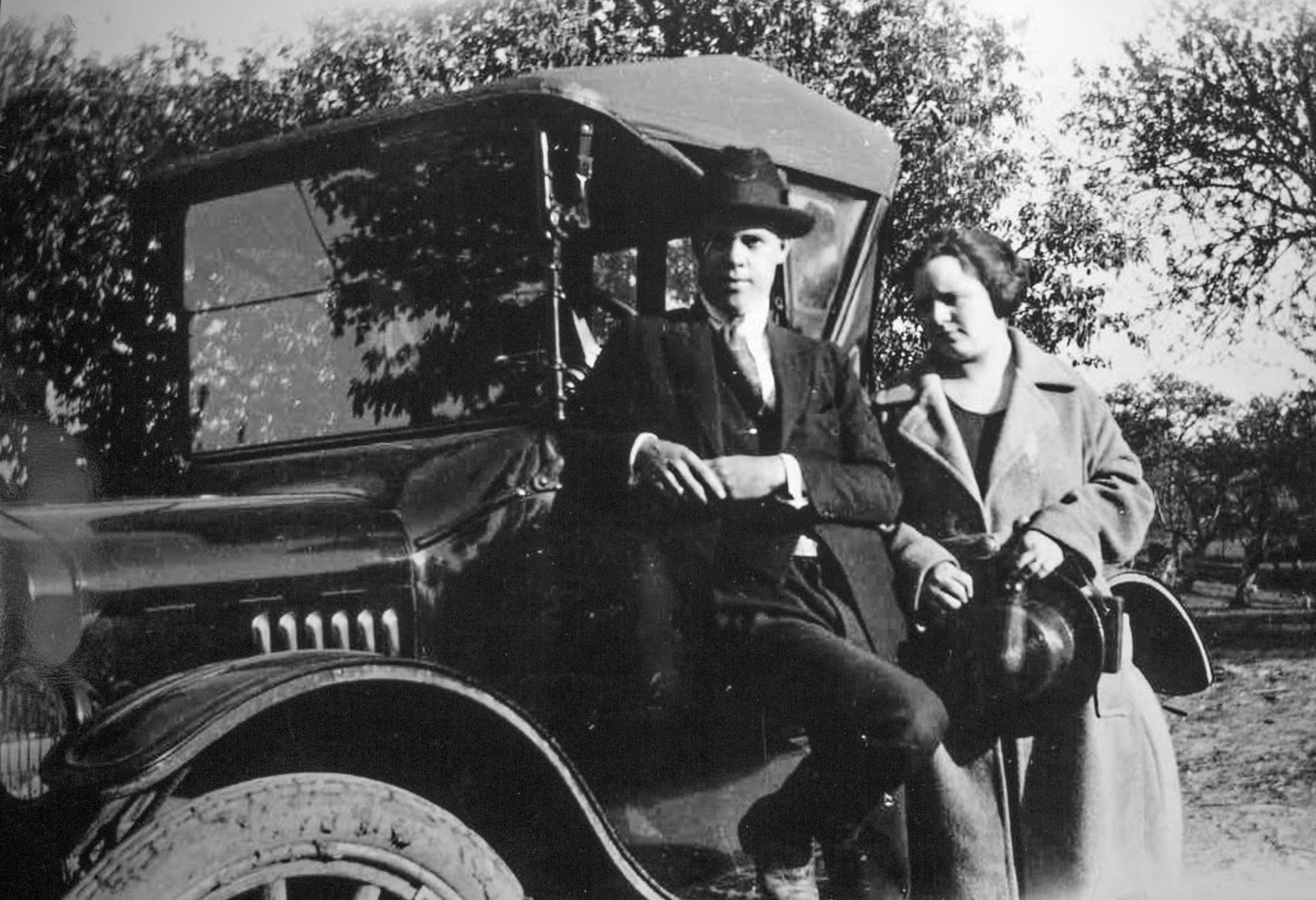 A black and white photograph of Robert Clark's parents Earl and Carmen standing in front of their Model-T Ford