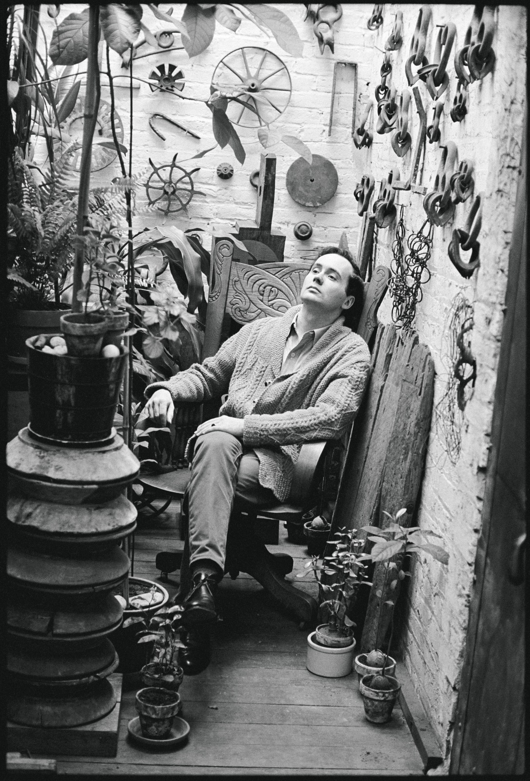 Robert Indiana sitting in the plant room at his Coenties Slip studio