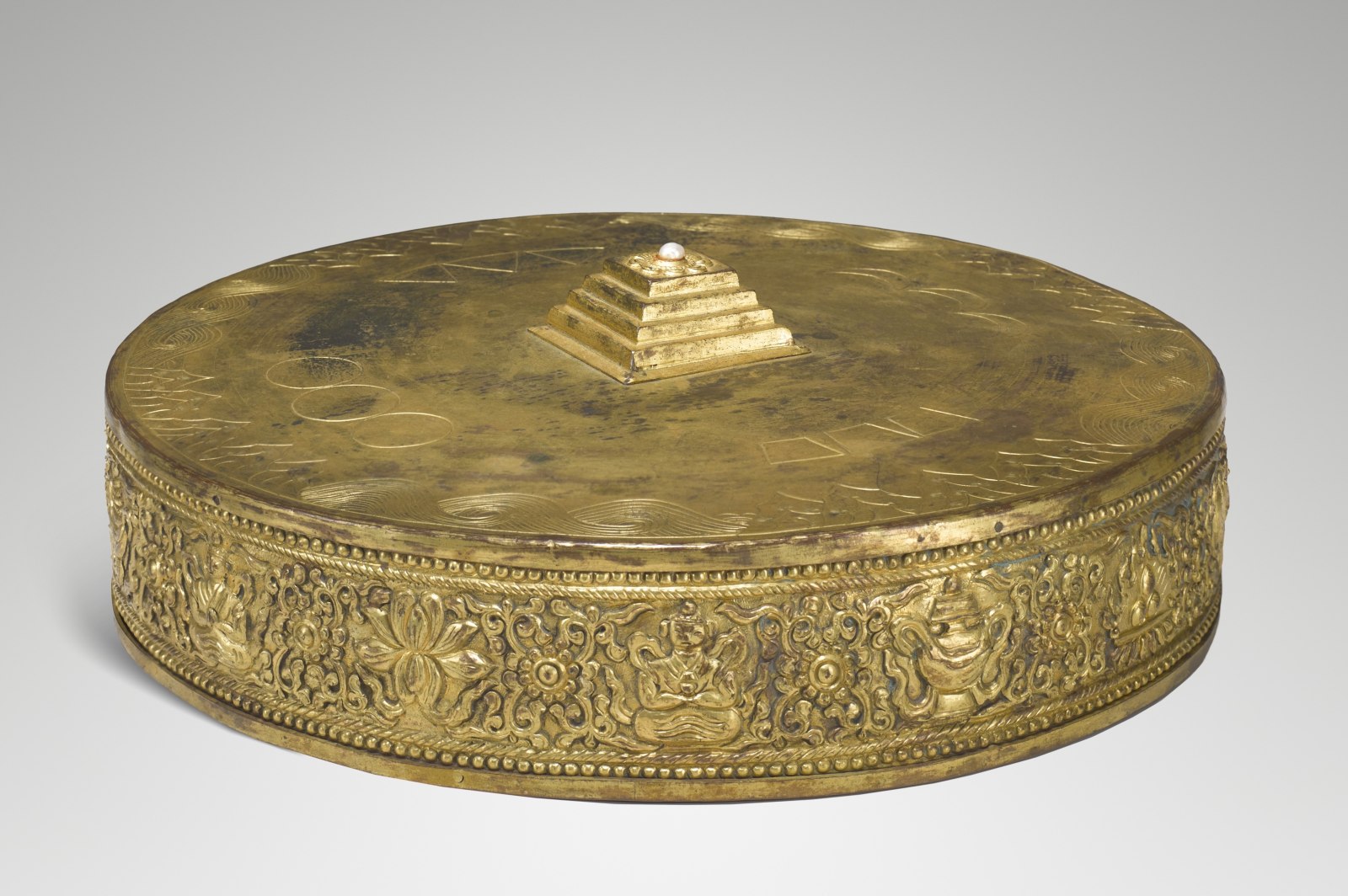 The five-terraced pyramid at the center of this three-dimensional metal mandala represents Mount Meru (or Sumeru), the cosmic mountain that in Indian cosmology is the axis of the universe and the dwelling place of the gods. 