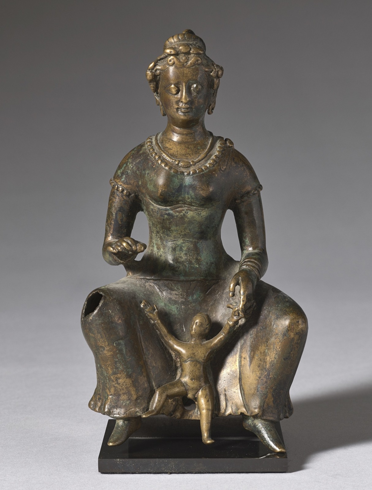 Same image of a Small bronze sculpture of a seated mother with her child playing between her legs