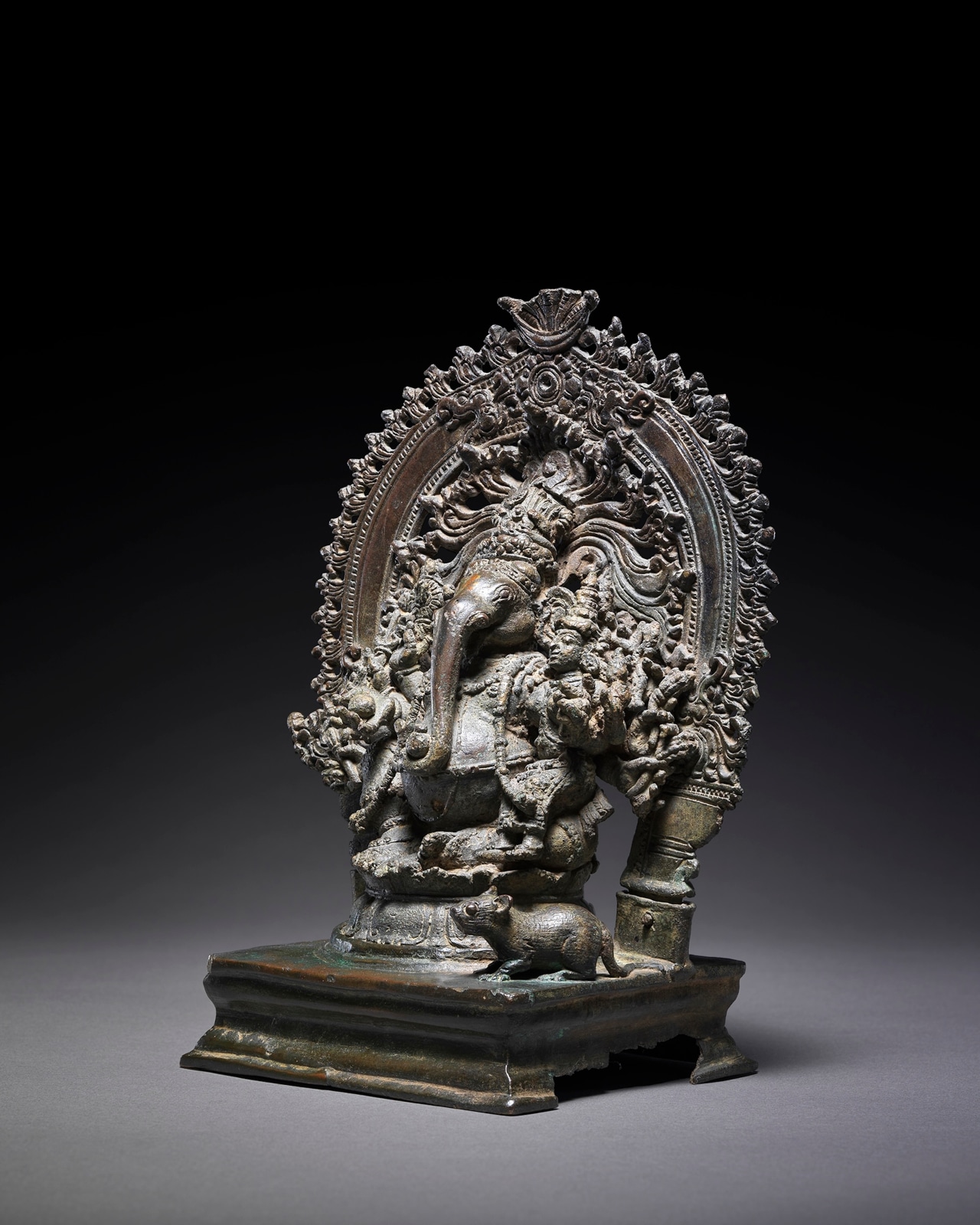  The corpulent elephant-headed divinity is seated in rajalilsana on a lotus throne. 