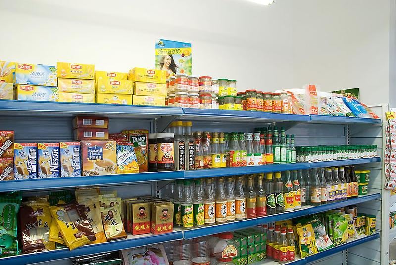 supermarket shelves stocked with food and empty bottles of product