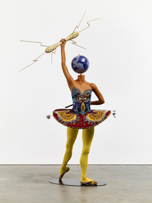 mannequin with a globe for a head holding a lightning rod