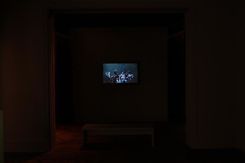 installation view of a dark room with several videos