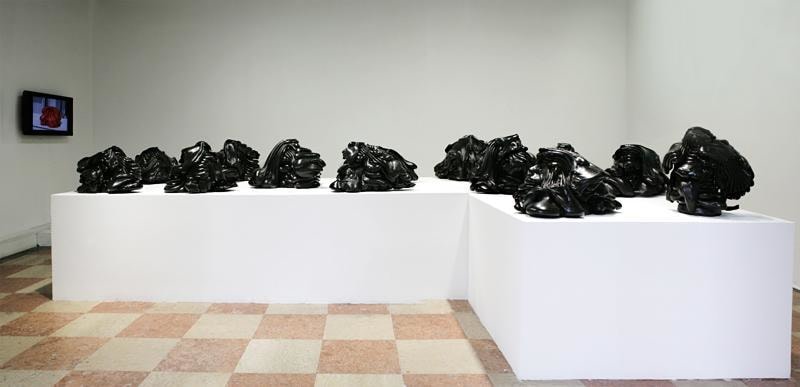 installation view of black blobs of paint on a table