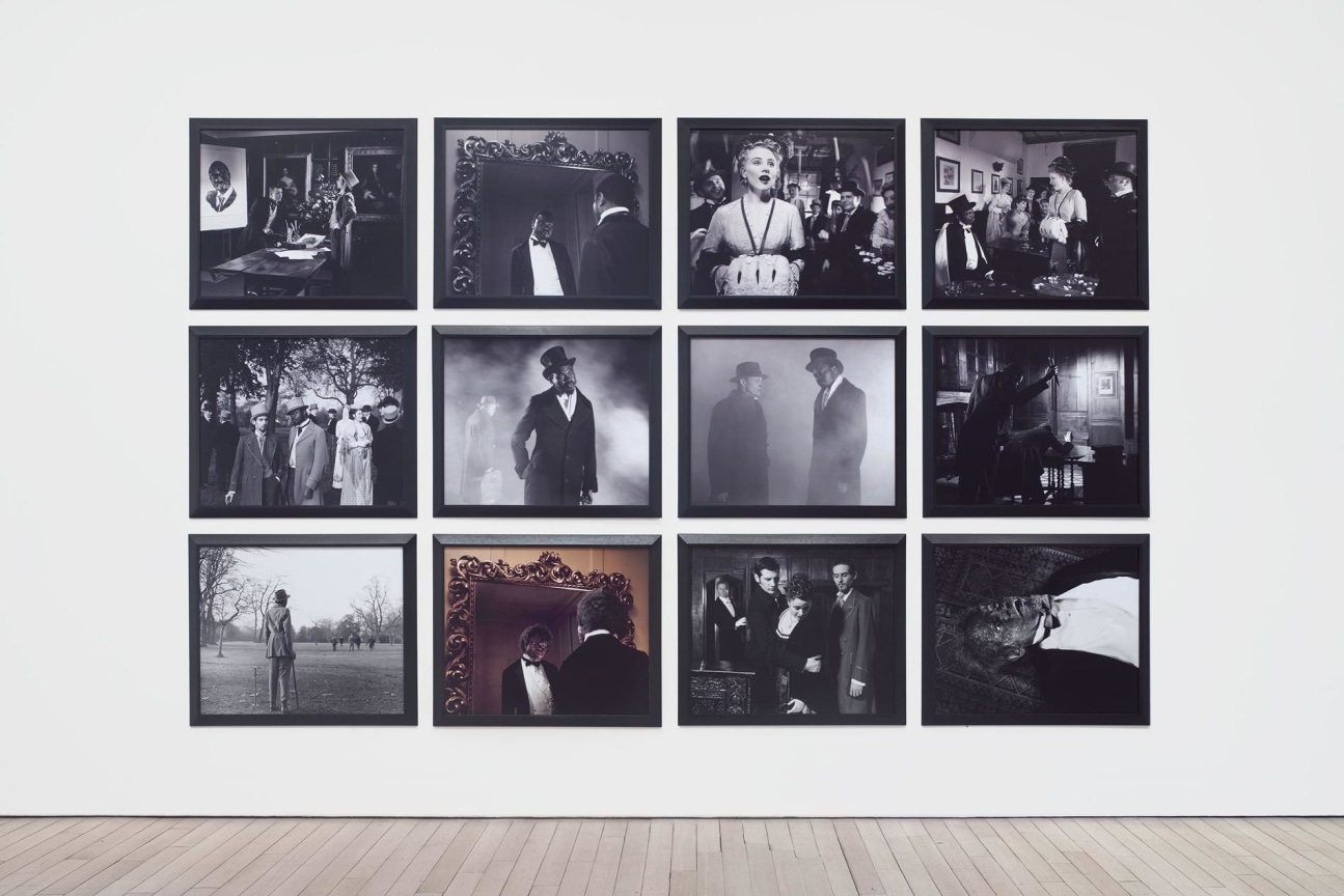 12 gray scale images hanging on a wall