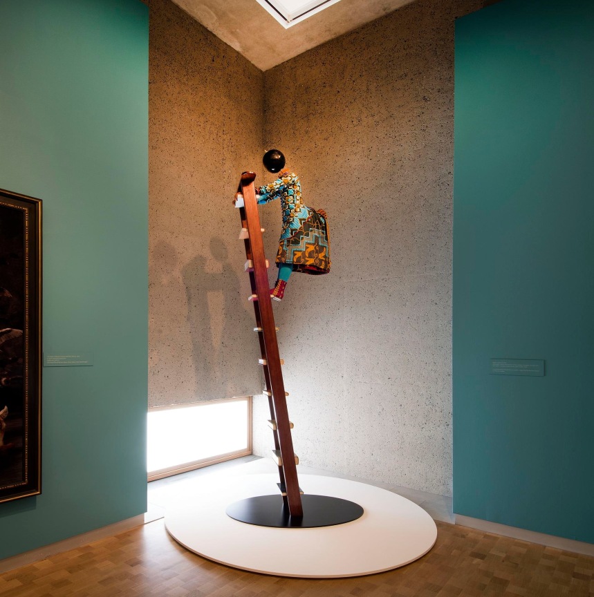 mannequin with a globe for a head climbing up a ladder with books for steps