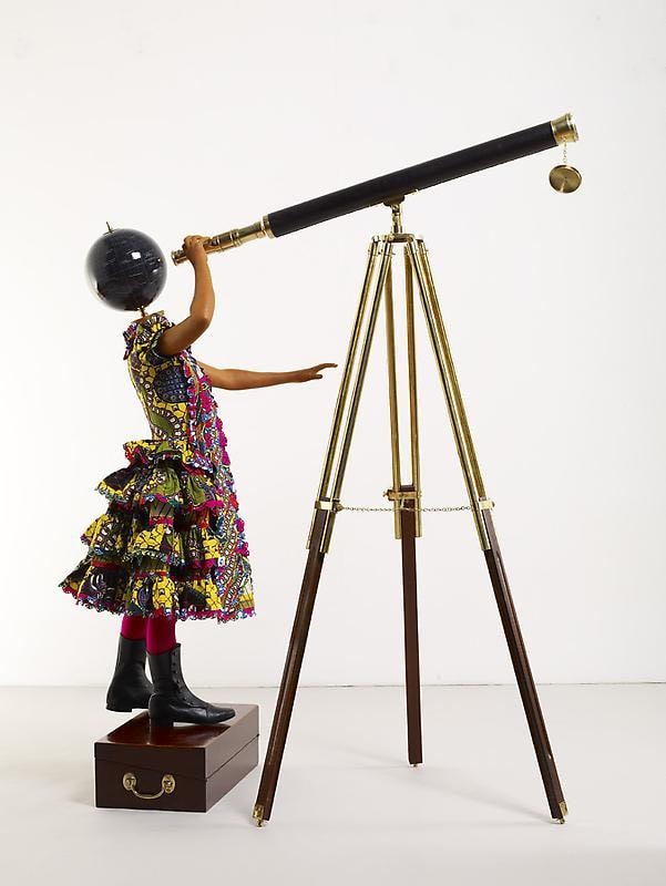 mannequin with a globe for a head looking through a telescope