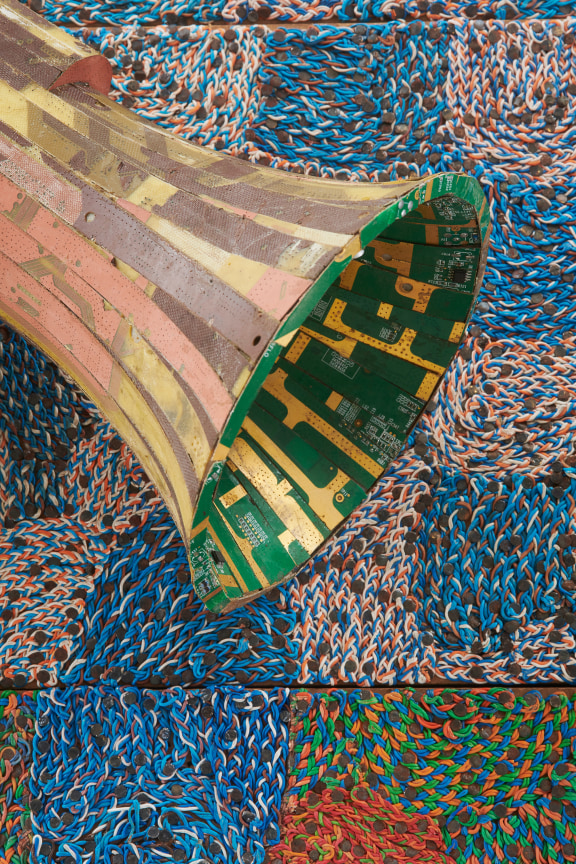 detail of a megaphone made of electrical components emerging from a panel containing electrical wiring