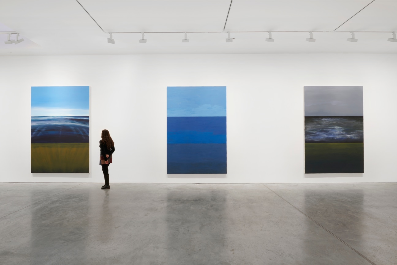 person viewing one of three paintings