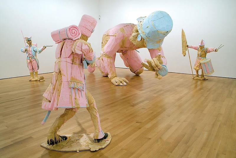 installation view of several statues, including a giant one