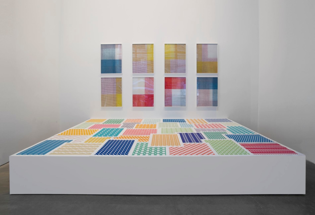 platform with fabric patterns with framed pieces of fabric in the back wall