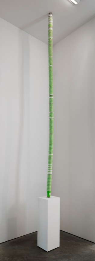 Stacks of mostly green cups from pedestal to ceiling by SIMON EVANS&trade;.