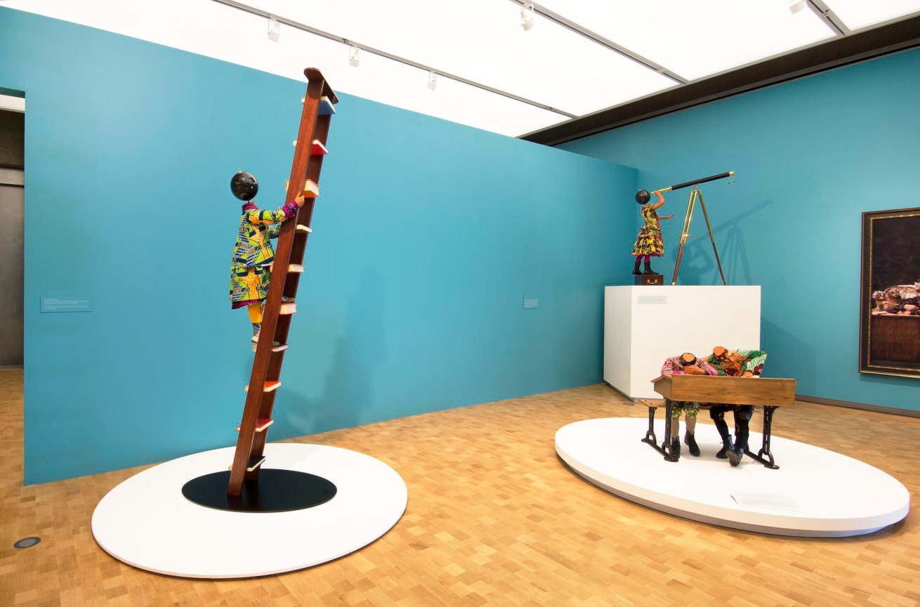 installation view of multiple mannequins engaging in miscellaneous activities regarding learning