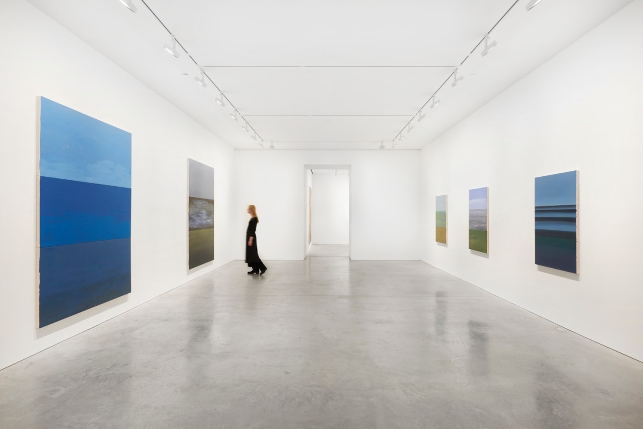 person walking through the long gallery with paintings
