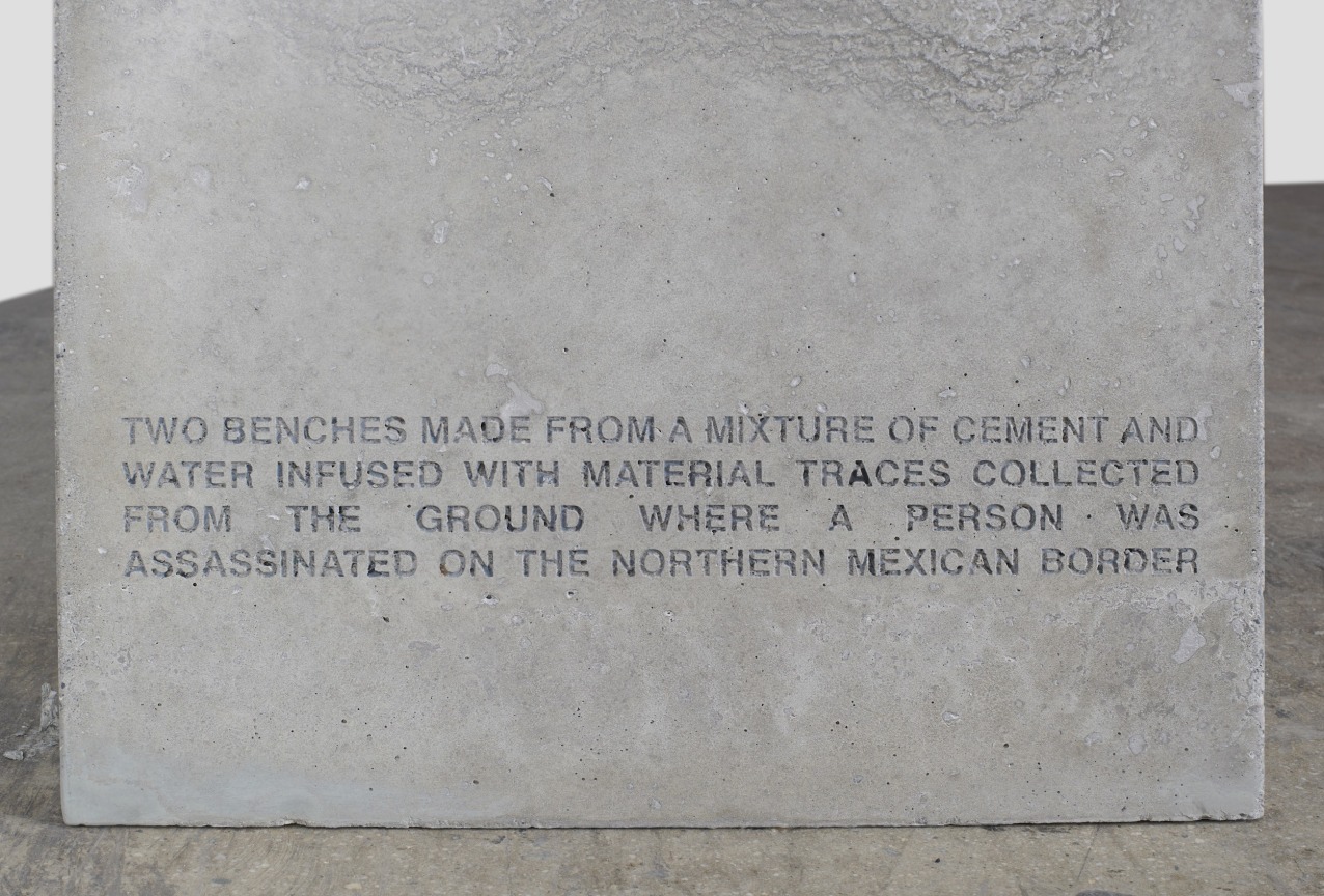 Inscription on cement bench reads Two Benches Made From A Mixture Of Cement And Water Infused With Material Traces Collected From The Ground Where A Person Was Assassinated On The Northern Mexican Border