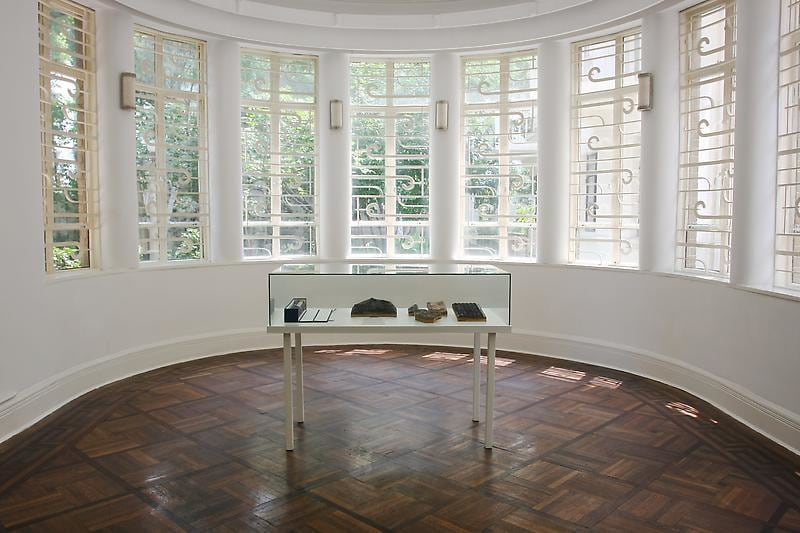 installation view of a glass case with works inside it