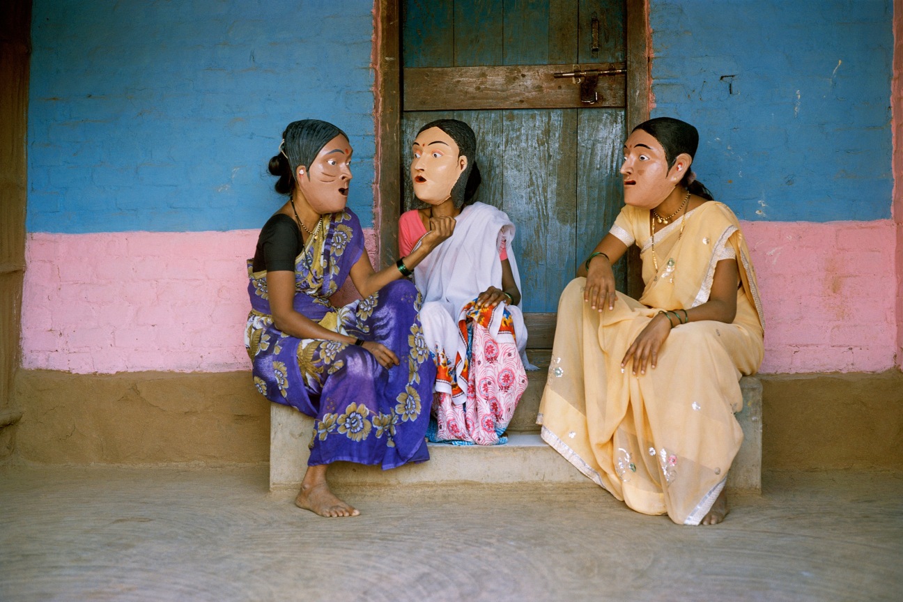 Archival pigment print featuring three people in paper Mache masks