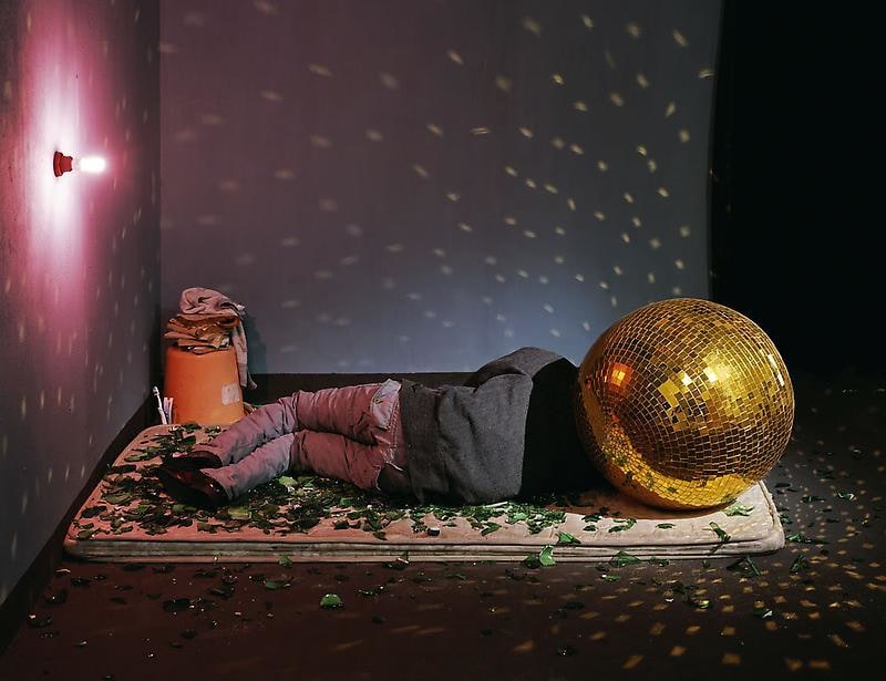 person with a mirror ball for a head sleeping