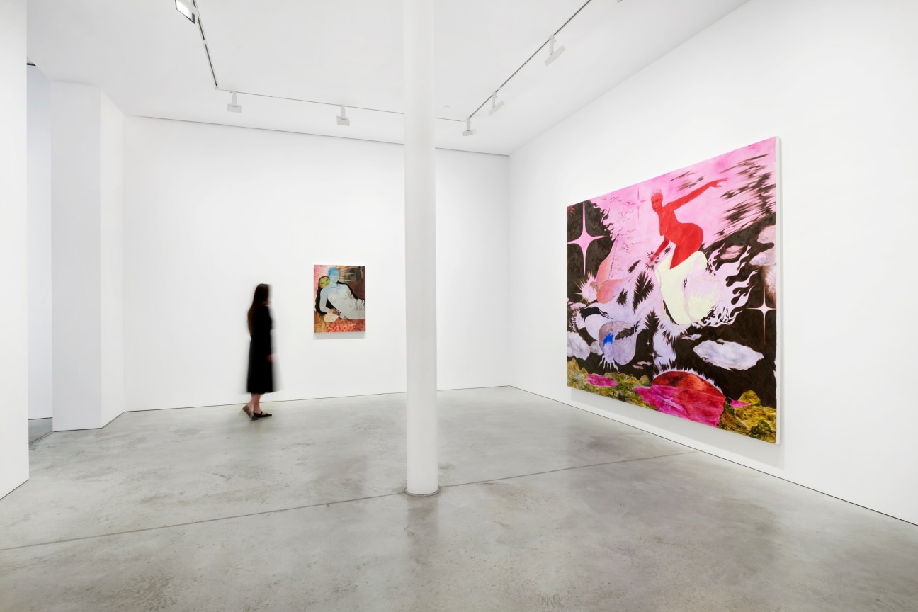 person walking through a gallery with paintings