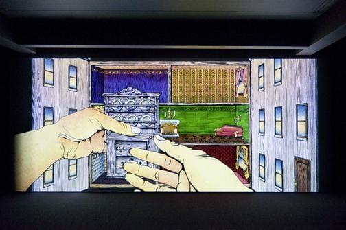 hand holding a miniature pantry looking to place it within an open dollhouse-like building