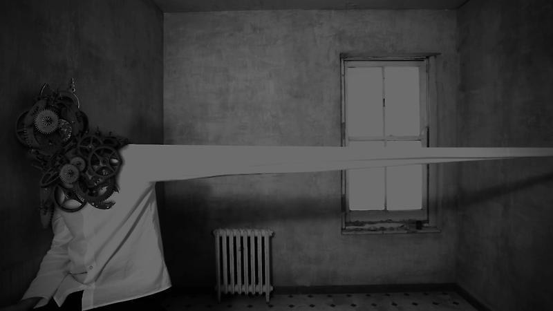 a man covered in gears extends their arm at an exaggerated length within a barren room