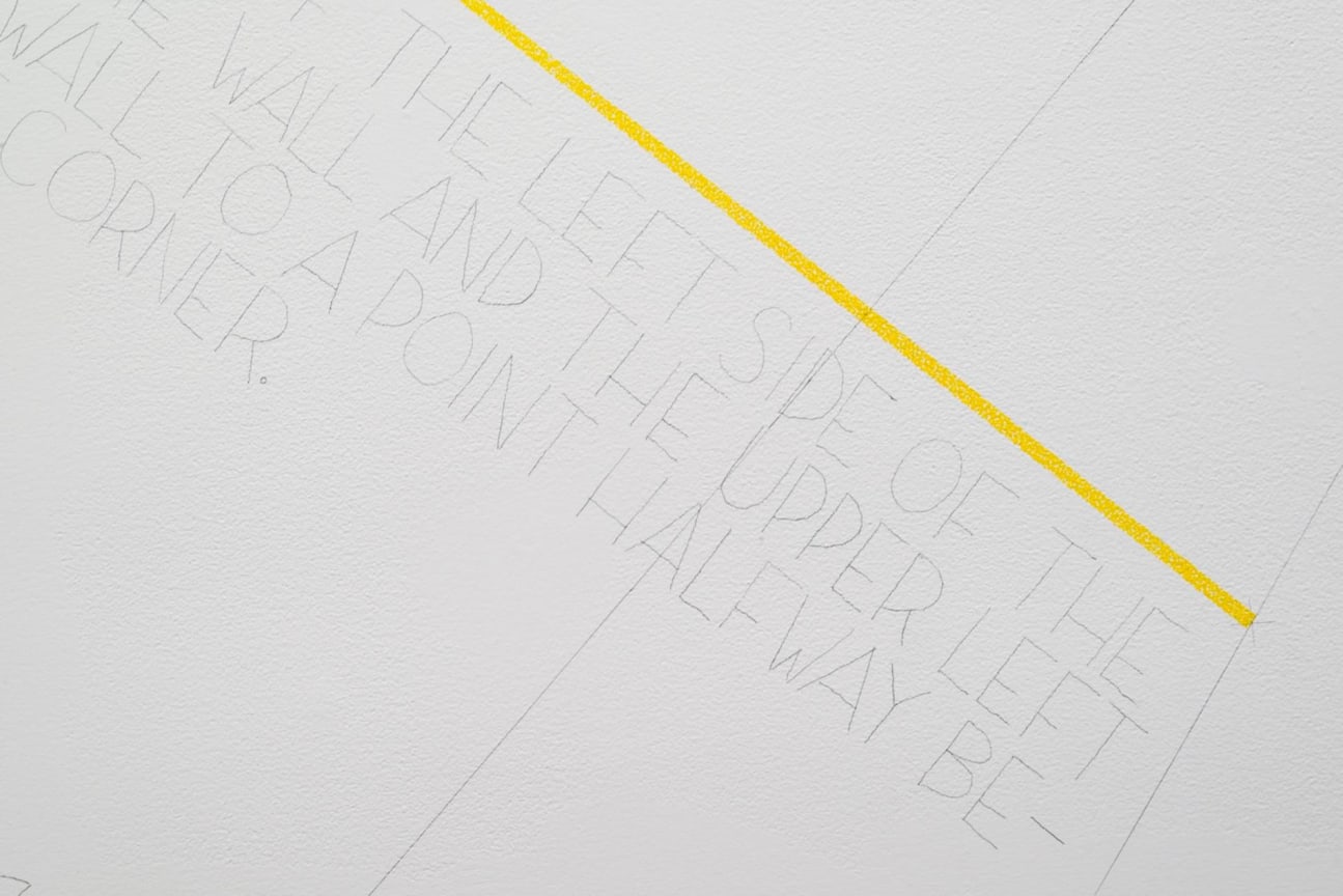 yellow line with text underneath it drawn directly on the wall