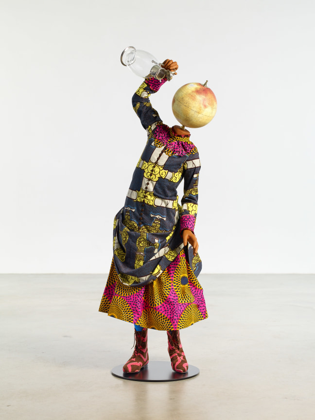 mannequin of a girl with a globe for a head holding up a pitcher