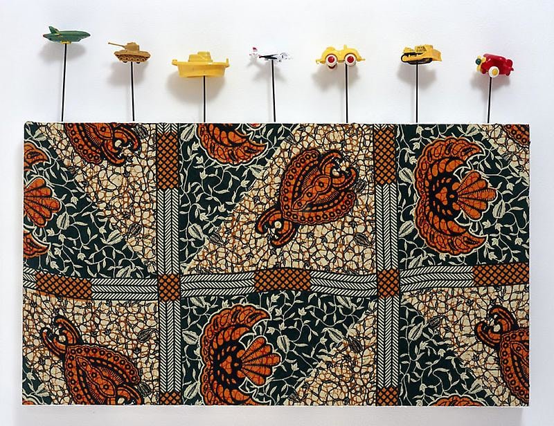 painting on textile with small toys attached to its borders