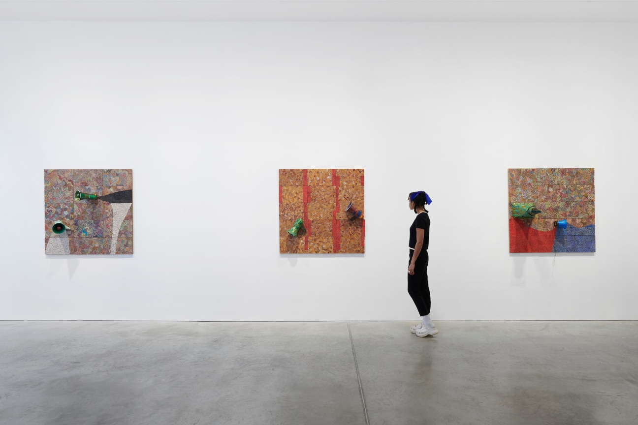 person looking at one of three artworks