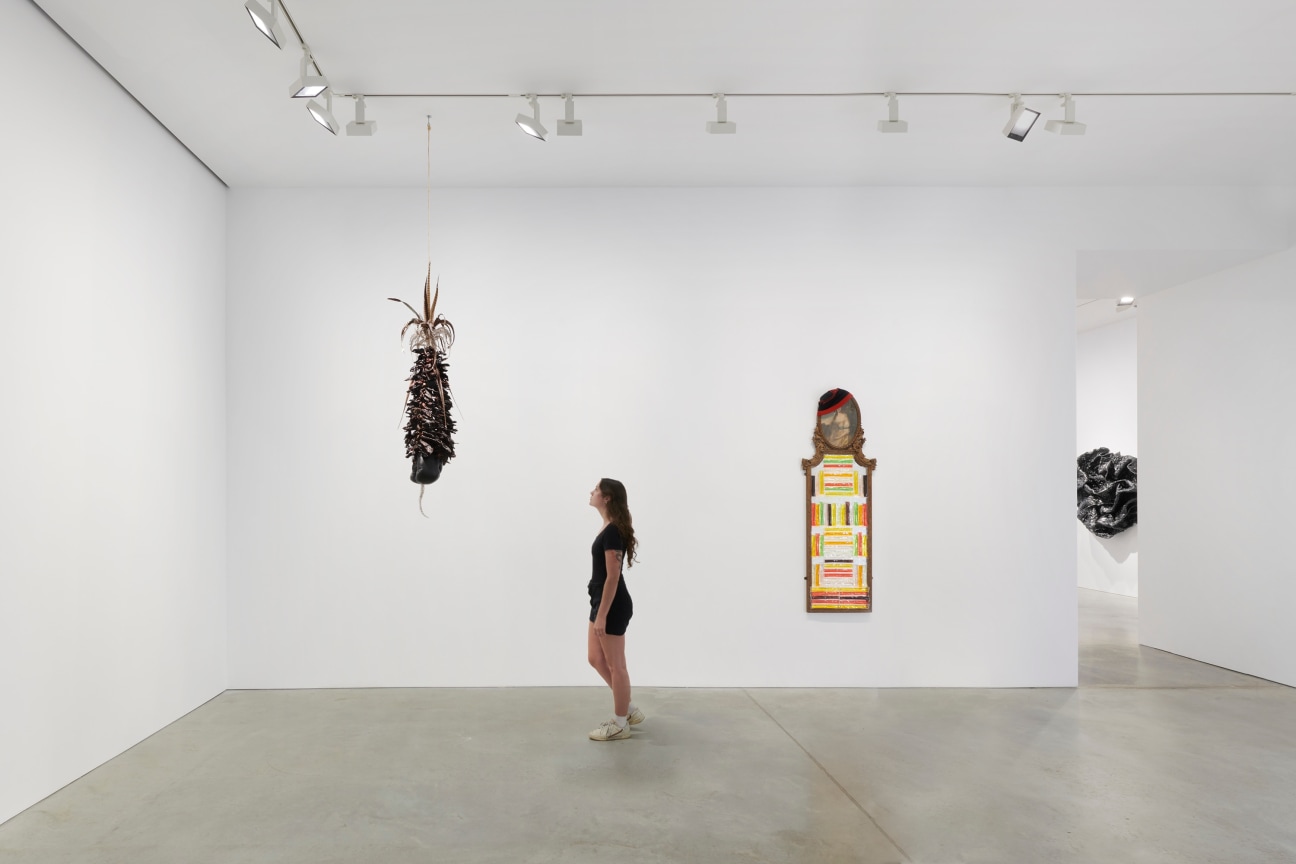 person looking at an artwork hanging from the ceiling