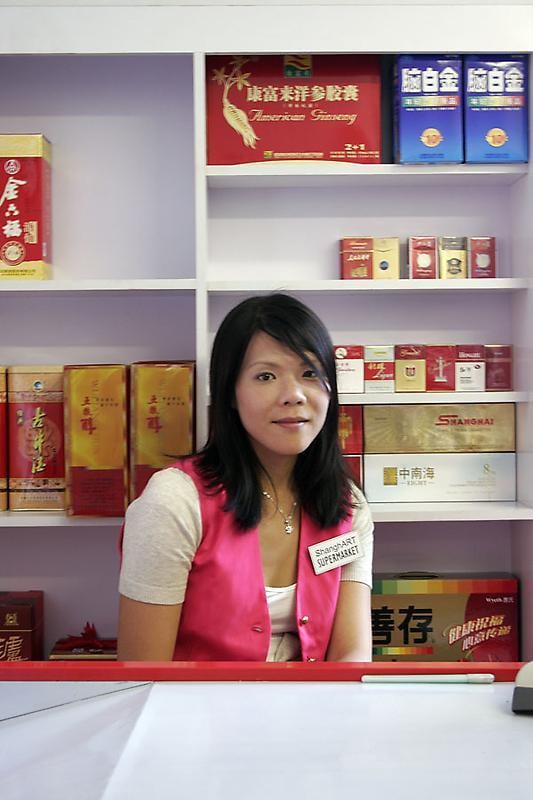 A feminine figure sitting inside a convenience store