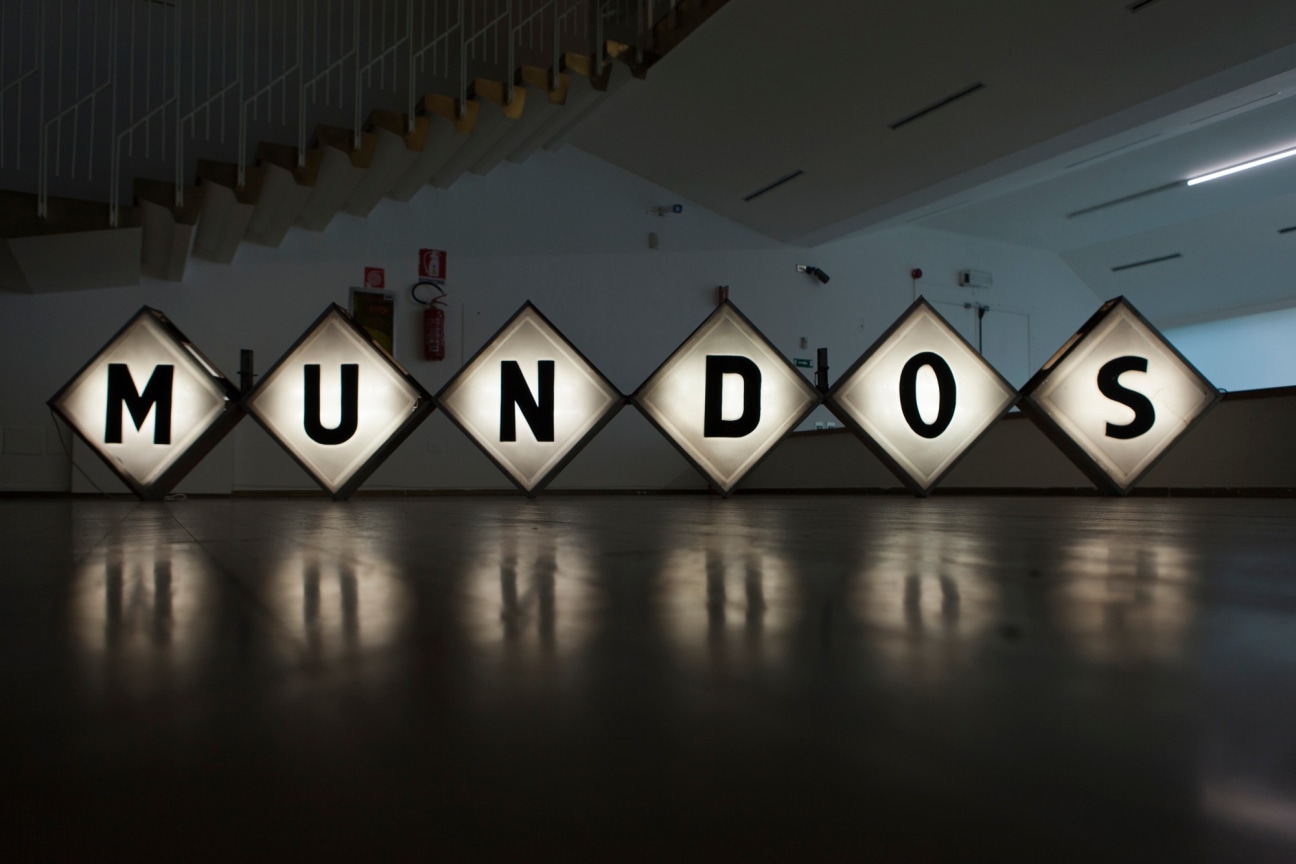Six square neon signs placed on floor reads MUNDOS