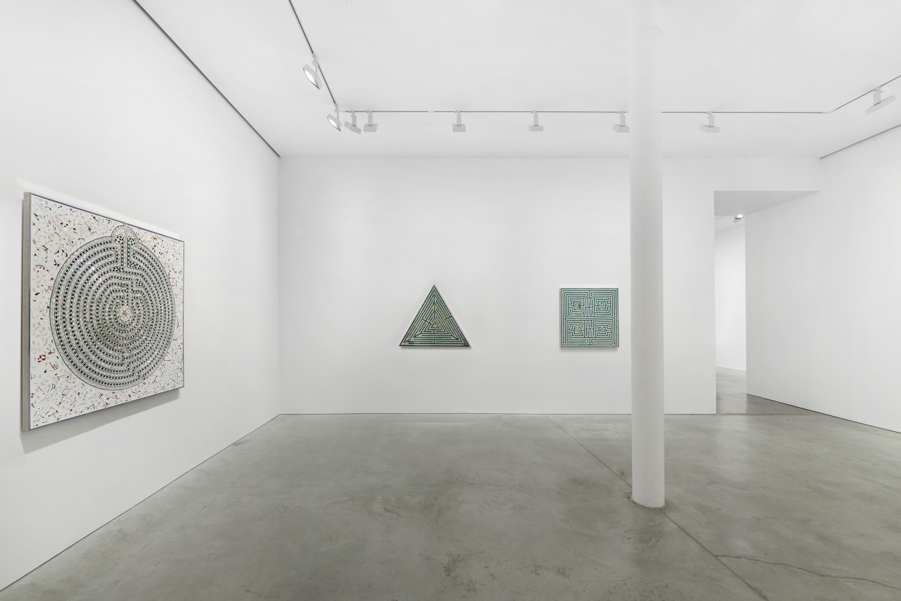 view of white gallery containing three art pieces