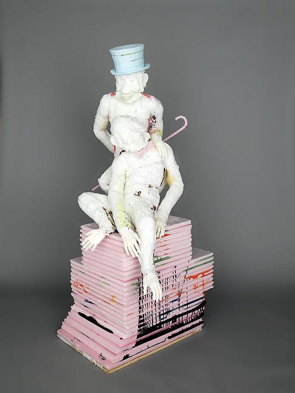 two white apes, one with a ha and another with a bow tie, on top of a pink pedestal