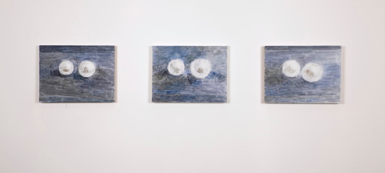 installation view of three paintings depicting two pearls each