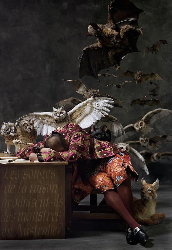 white man asleep on his desk with several animals behind him