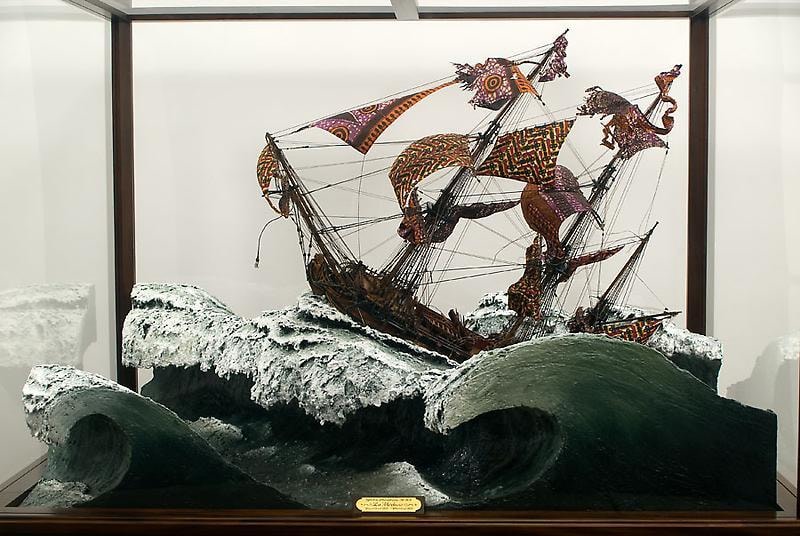 close up of a sculpture of violent waves and a ship with tattered sails