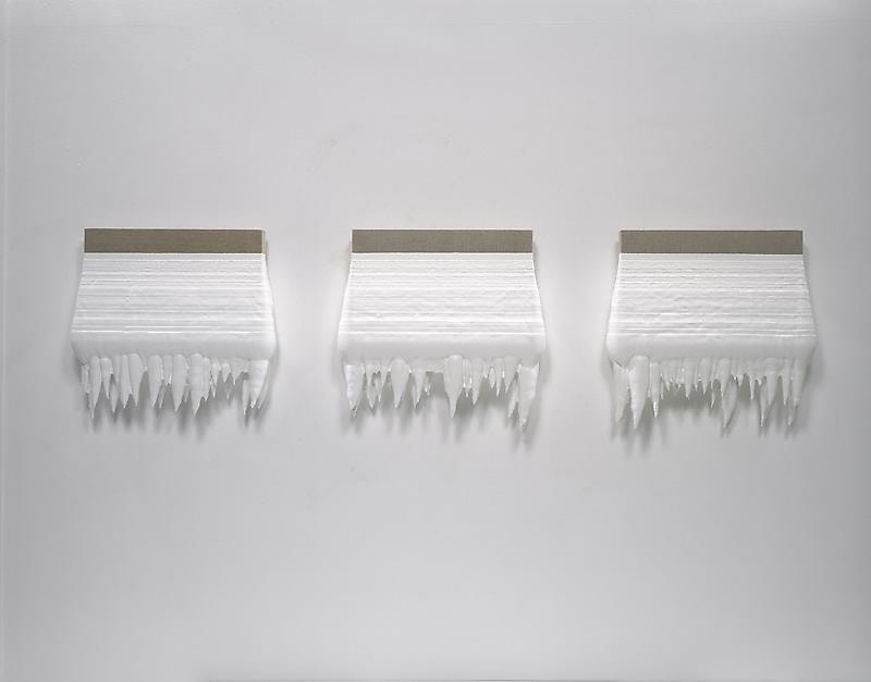 three linen canvases dipped in thick, dangling, white paint