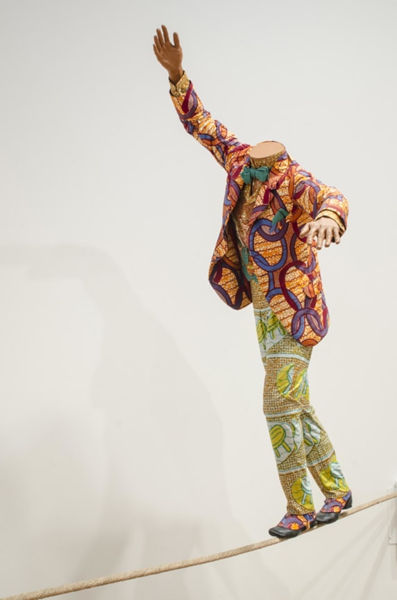 headless mannequin walking on a tightrope