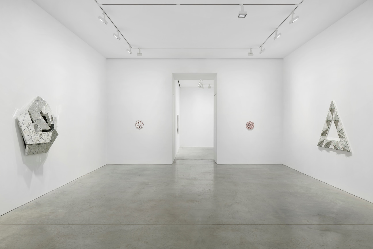 view of several glass artworks and a hallway leading to the next gallery in the center