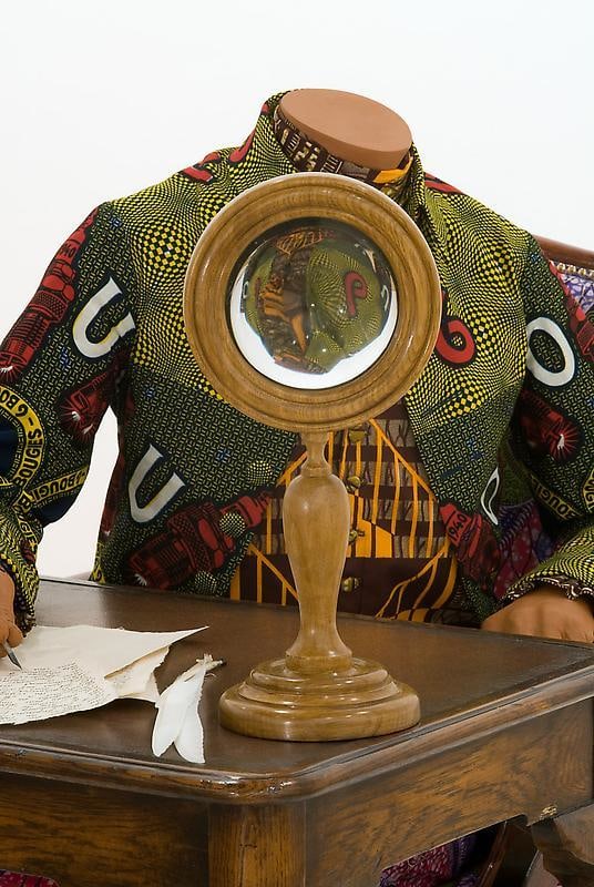 mannequin in a green vest writing
