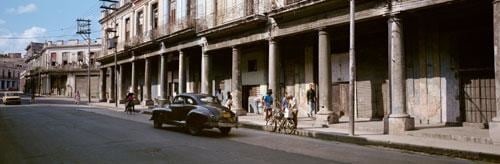 vintage black car in front of a building with poor maintenance